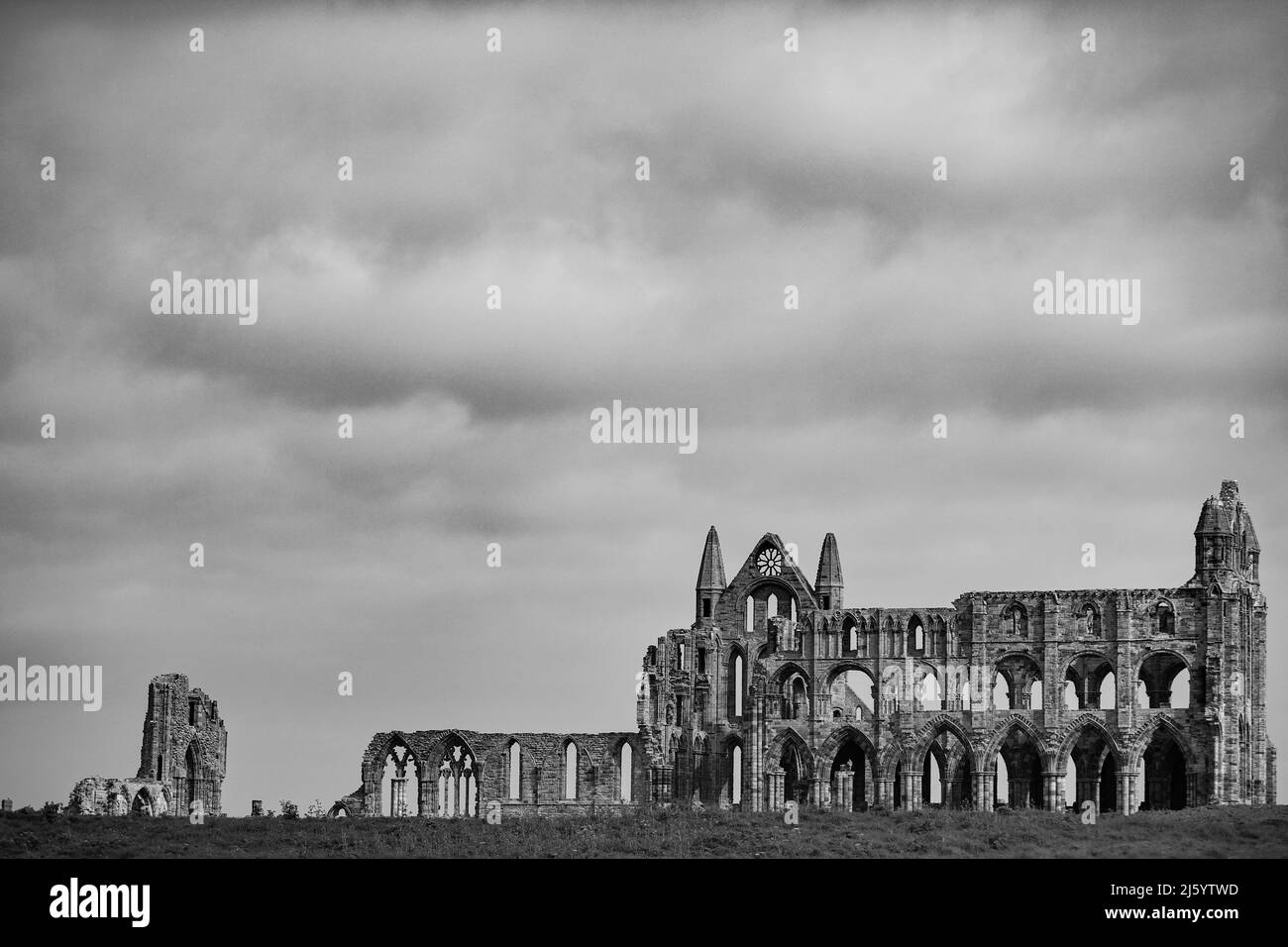 WHITBY, ENGLAND. April 25. 2022. (BILD IN SCHWARZ-WEISS konvertiert) Whitby Abbey vor einem launischen Himmel ist zu sehen. Stockfoto