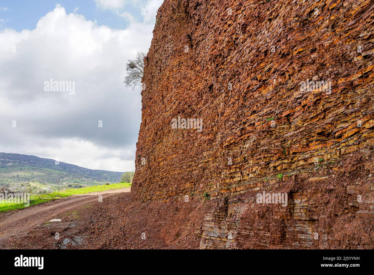 Traditionelle Landschaft in Zypern mit einer braunen, fein geschichteten Kalksteinklippe im Vordergrund Stockfoto