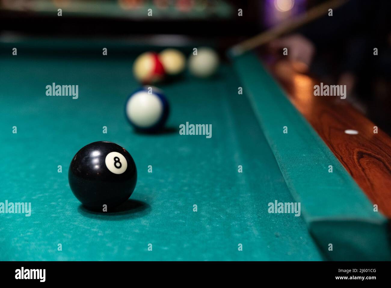 Black Ball mit der Nummer acht auf dem Billardtisch. Unscharfer Hintergrund. Stockfoto