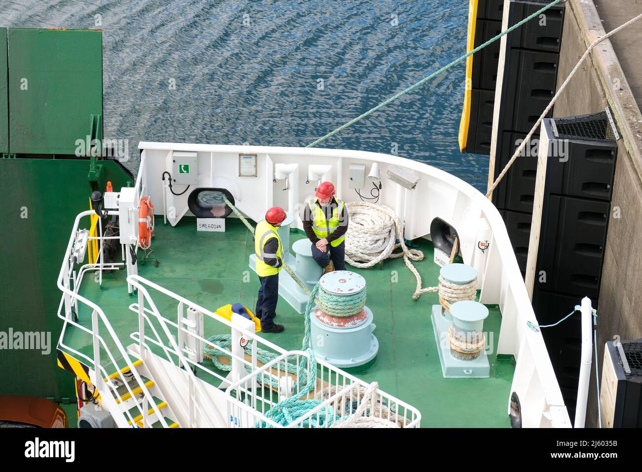 Crew-Mitglieder sprechen an Bord einer innerhebridischen Fähre der calmac, während sie sich auf den Ausweg aus dem Hafen vorbereiten. Stockfoto