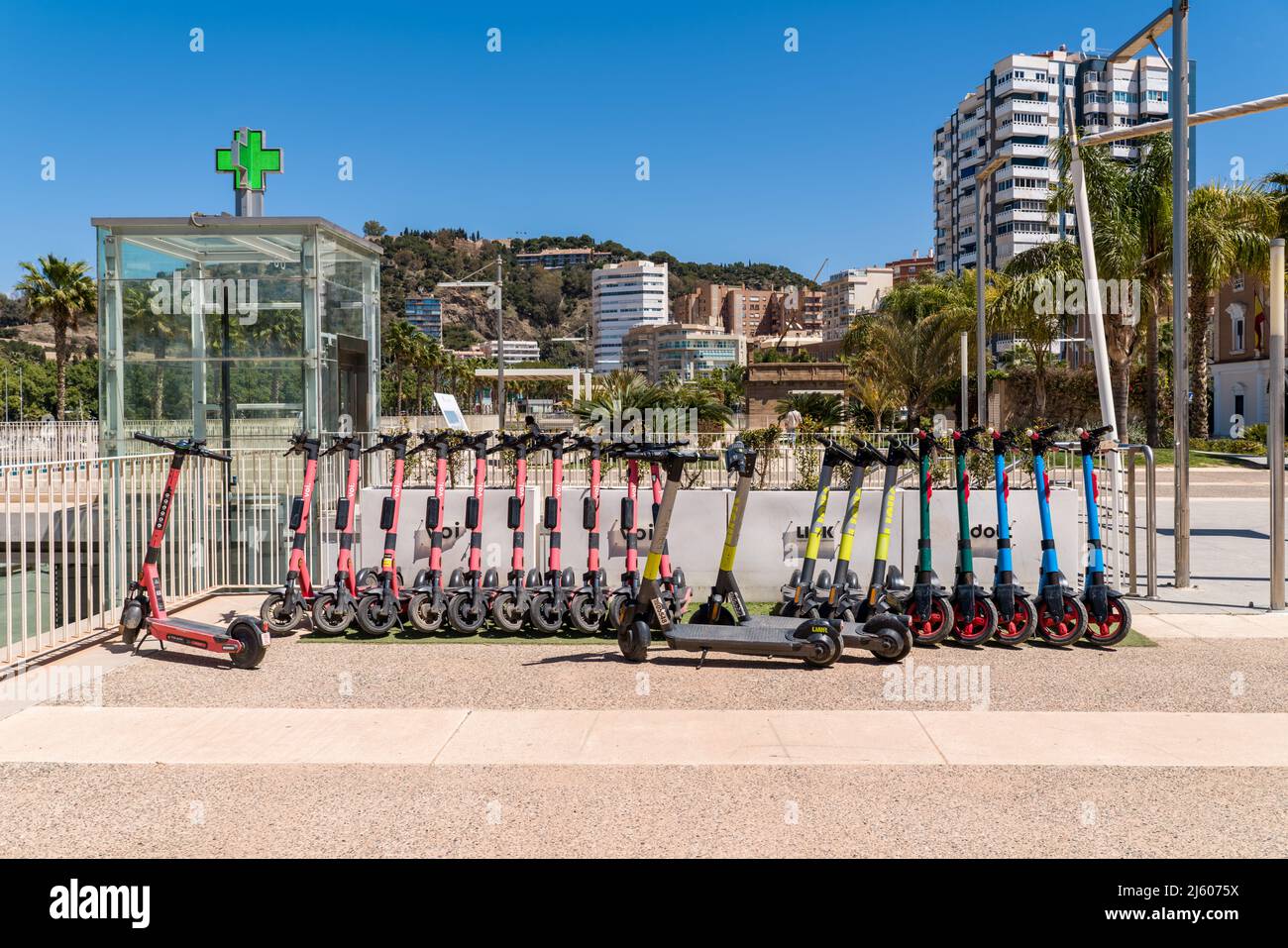 Parkplatz für Elektroroller, an der Strandpromenade des Hafens von Malaga. Link, Dott, VOI Motorroller zur Miete auf der Promenade 'Muelle Uno'. Stockfoto