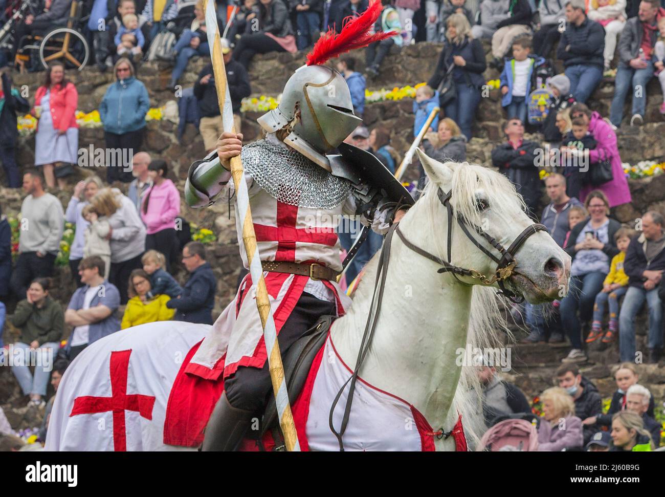 Ein Ritter auf dem Pferderücken trägt einen Reitstock, während er während der Großen mittelalterlichen Joust in Tamworth Castle am Tag von St. George eine Körperrüstung trägt. Stockfoto