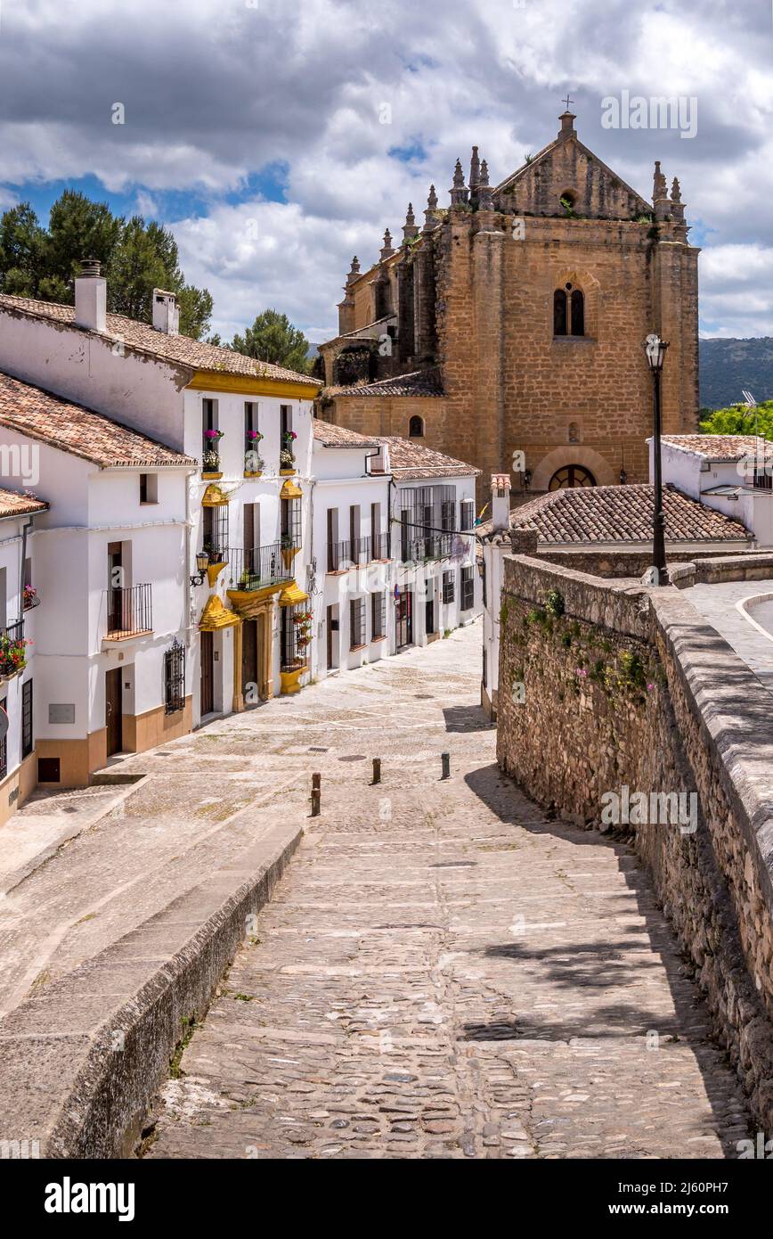 Kopfsteinpflasterstraße in Ronda, Andalusien, Spanien, die zu einer Kirche führt. Stockfoto