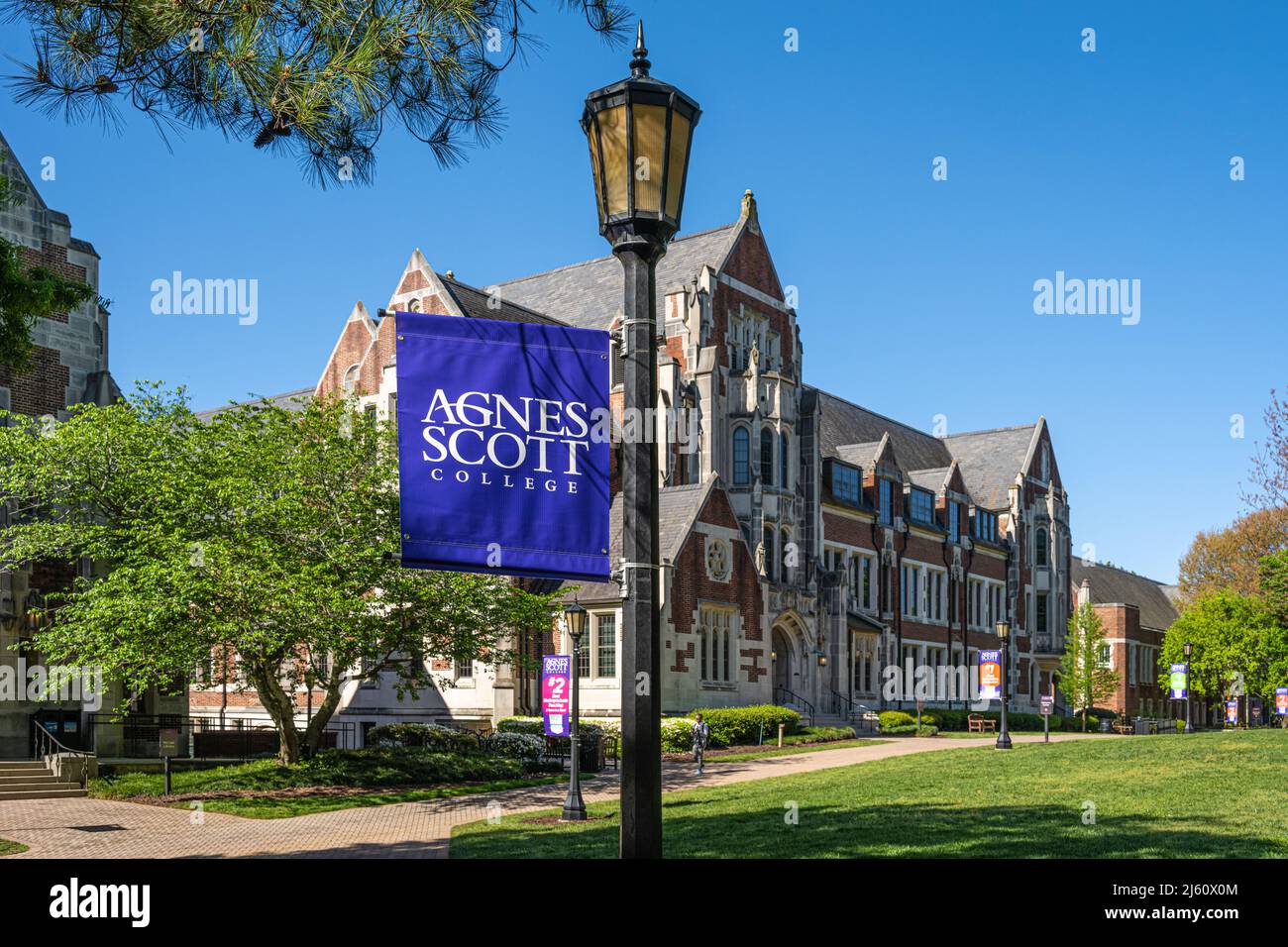 Agnes Scott College Lamppost-Banner auf dem Campus Quad mit der neugotischen Architektur von Buttrick Hall im Hintergrund. (USA) Stockfoto