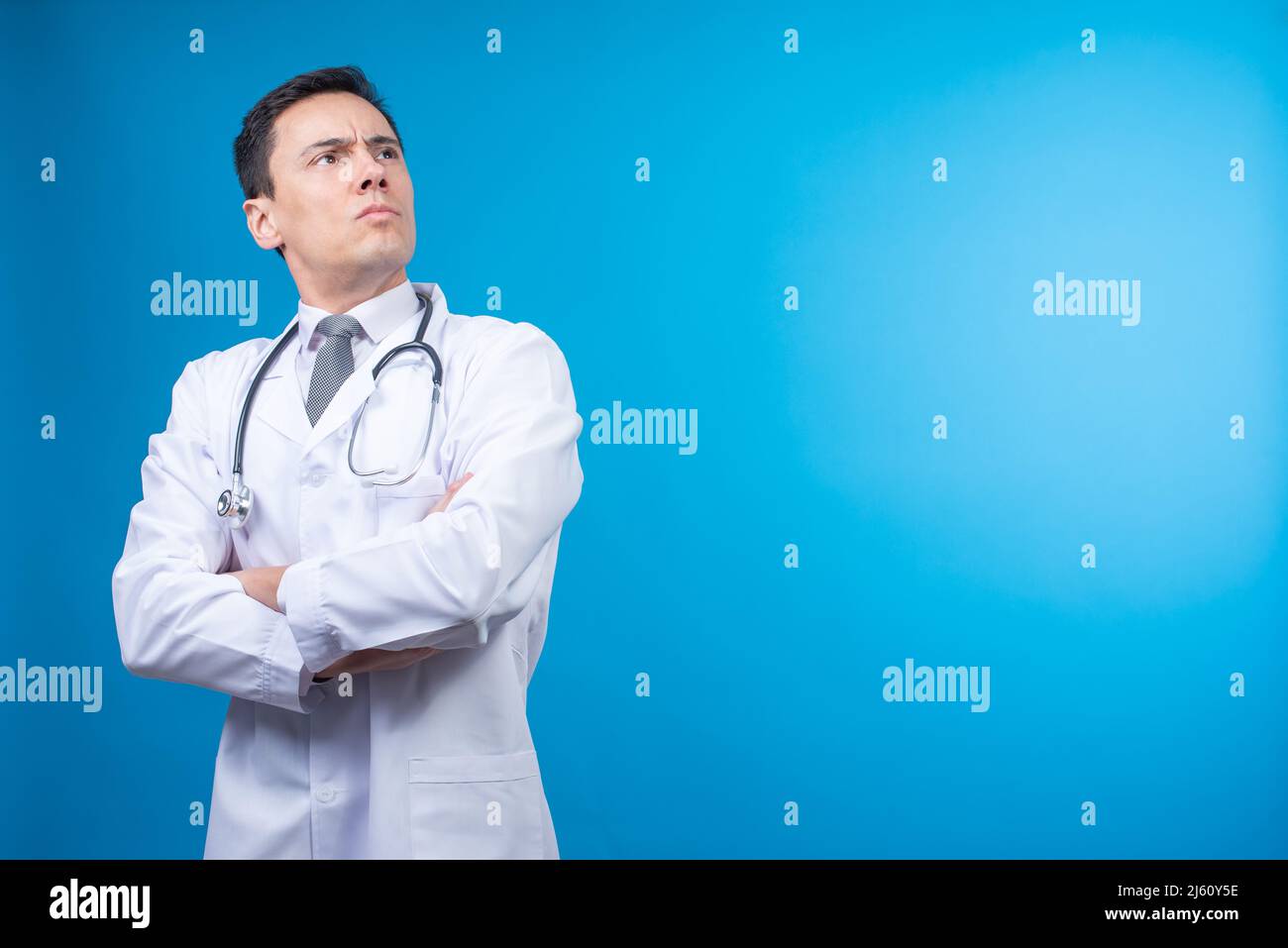 Selbstbewusster Arzt mit gekreuzten Armen im Studio Stockfoto