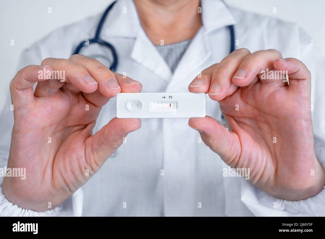 Der Arzt hält eine Express-Testkassette für Hepatitis oder Coronovirus in den Händen Stockfoto