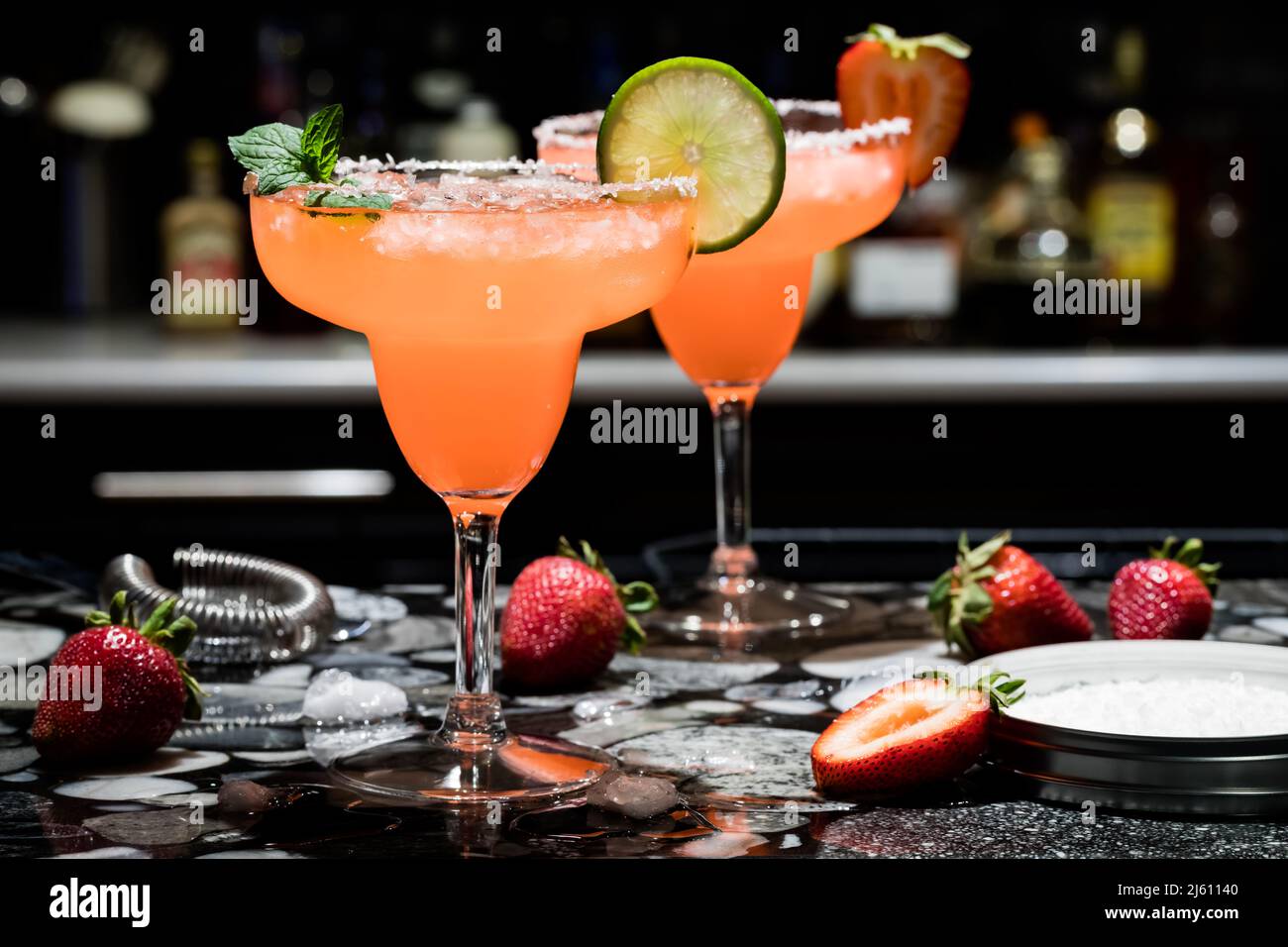 Zwei Erdbeermargaritas auf einer Bar, vor dunklem Hintergrund. Stockfoto