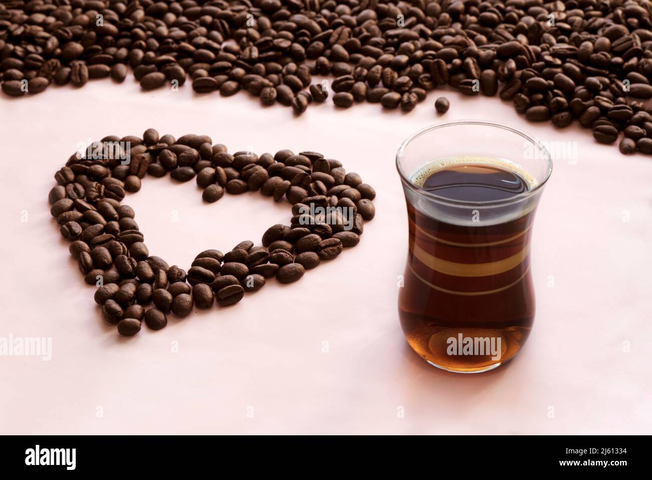 Valentinstag oder Hochzeit, Liebe, Schwarz, Rahmen. Herzförmige Kaffeebohnen. Kaffeebohnen in Form einer Tasse mit Herz Stockfoto