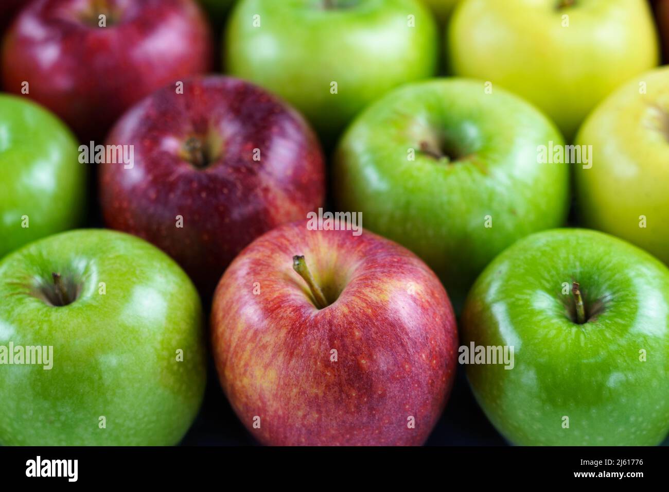 Hintergrund von farbigen Äpfeln diagonal angeordnet mit Rückenunschärfe. Stockfoto