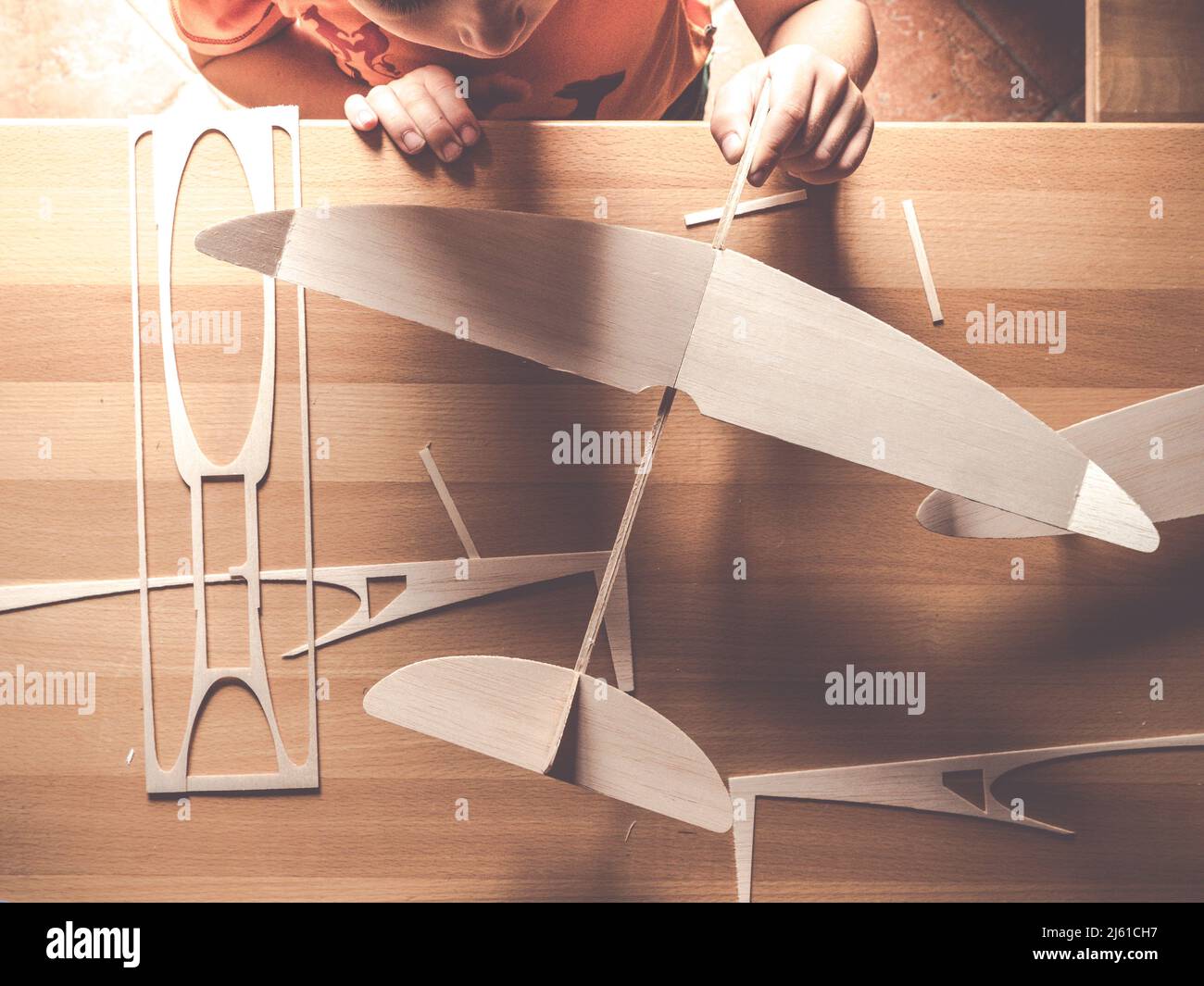 Draufsicht auf Kinder Hand halten Balsa Holz Flugzeug-Kit oder fliegende Spielzeug Stockfoto