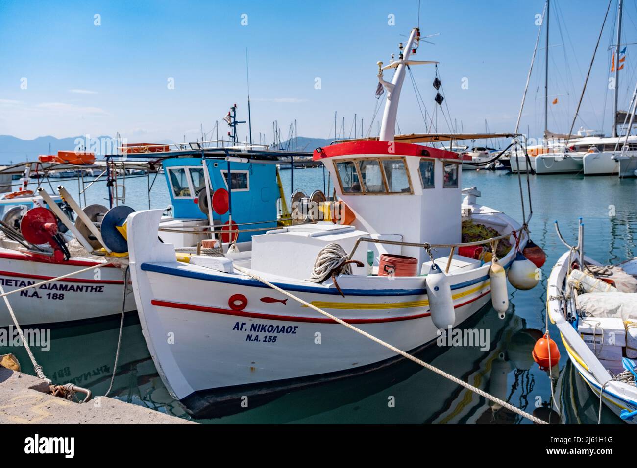 Aegina Island, Griechenland - 04.27.2022: Schöne griechische traditionelle kleine Fischerboote im Hafen der Insel Aegina, die an einem sonnigen Tag vor Anker liegen. Farbenfrohe Aussicht Stockfoto