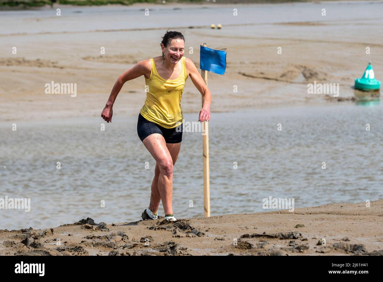 Weibliche Athletin beim Maldon Mud Race 2022 auf dem River Blackwater, Essex, Großbritannien. Stockfoto