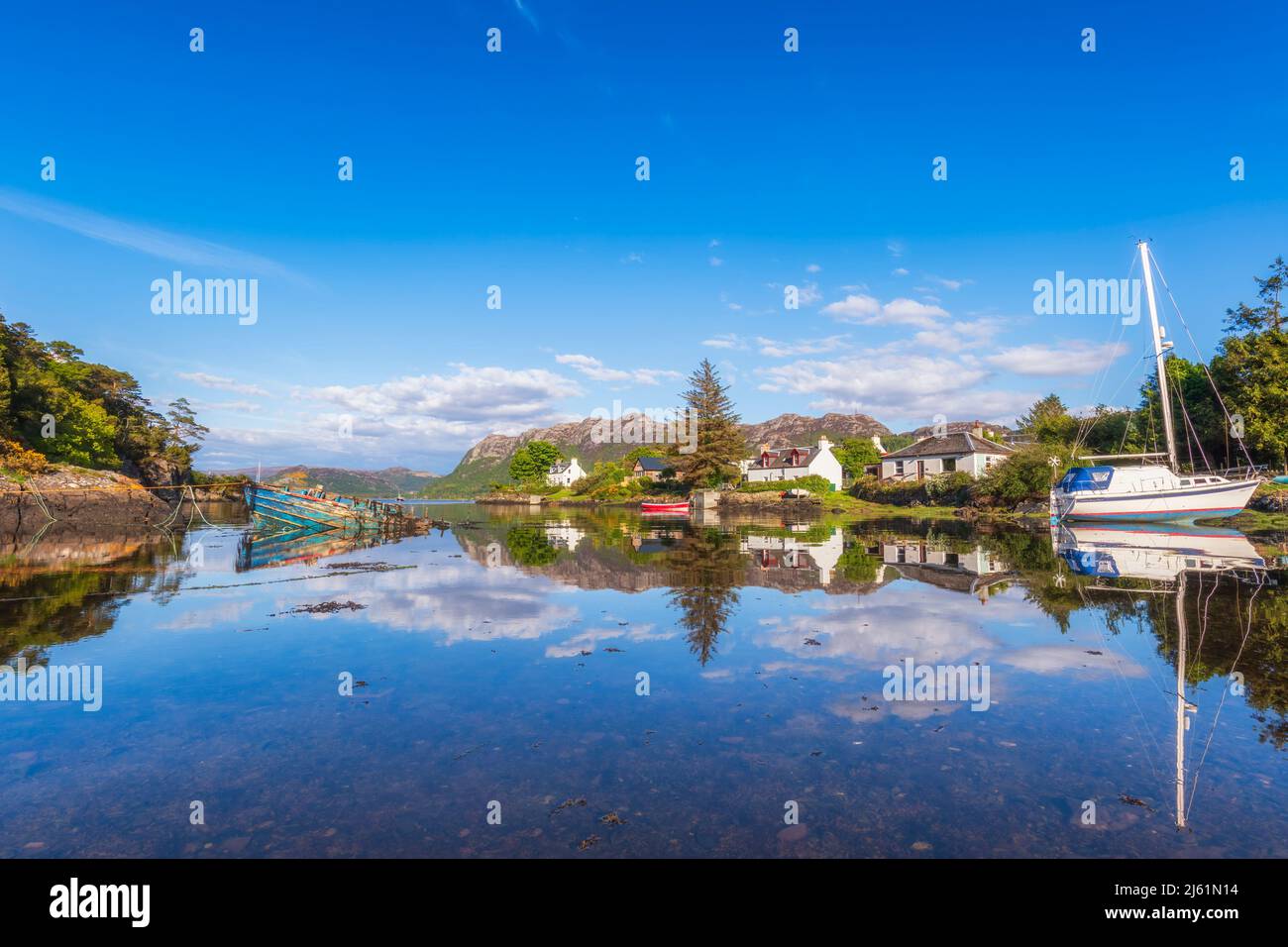 Malerisches Plockton Dorf und Boot reflektieren auf See, Schottland Stockfoto
