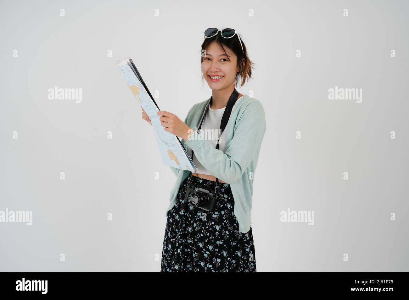 Reisende erkunden Traumtouristin asiatische Frau in legerer Kleidung Hut Kamera halten Papier Karte während der Exkursion auf weißem Hintergrund Passagierreisen Stockfoto