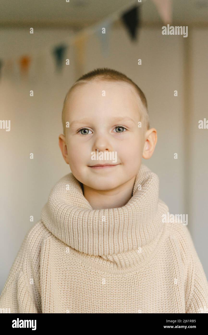 Lächelnder netter Junge mit Rollkragenpullover zu Hause Stockfoto