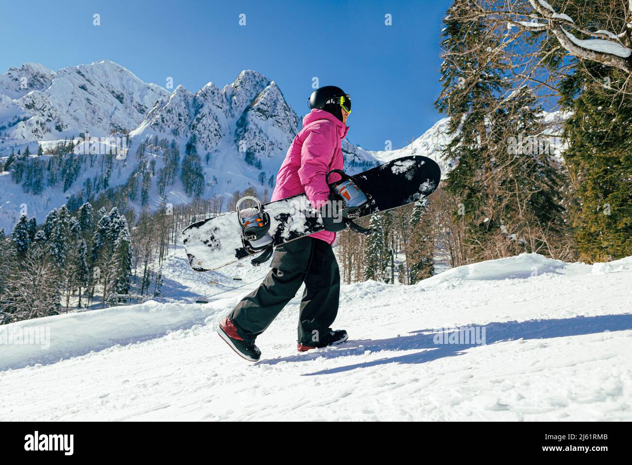 Mann mit Snowboard im Winter auf Schnee Stockfoto