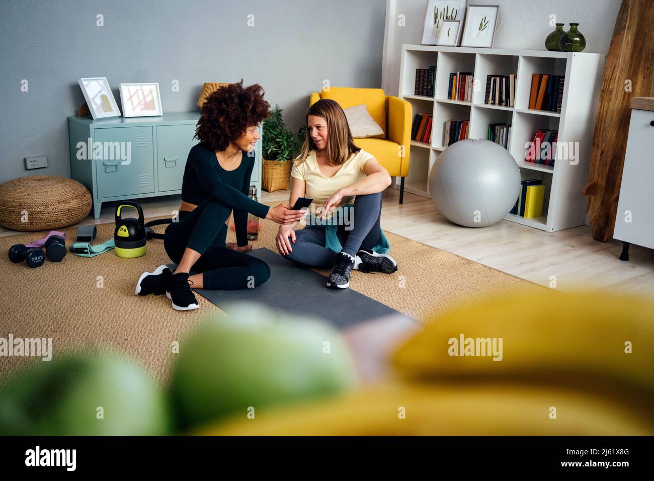 Frauen, die miteinander reden, sitzen zu Hause im Wohnzimmer Stockfoto
