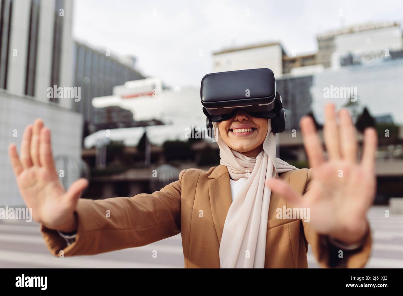 Glückliche Geschäftsfrau trägt virtuelle Realität Simulator gestikuliert Stop-Zeichen Stockfoto