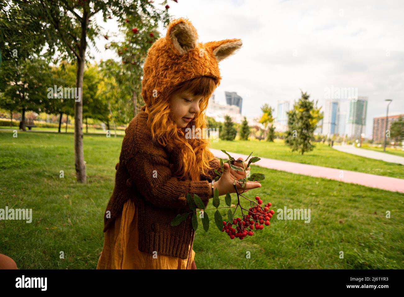 Mädchen hält Beerenobst Zweig im öffentlichen Park Stockfoto