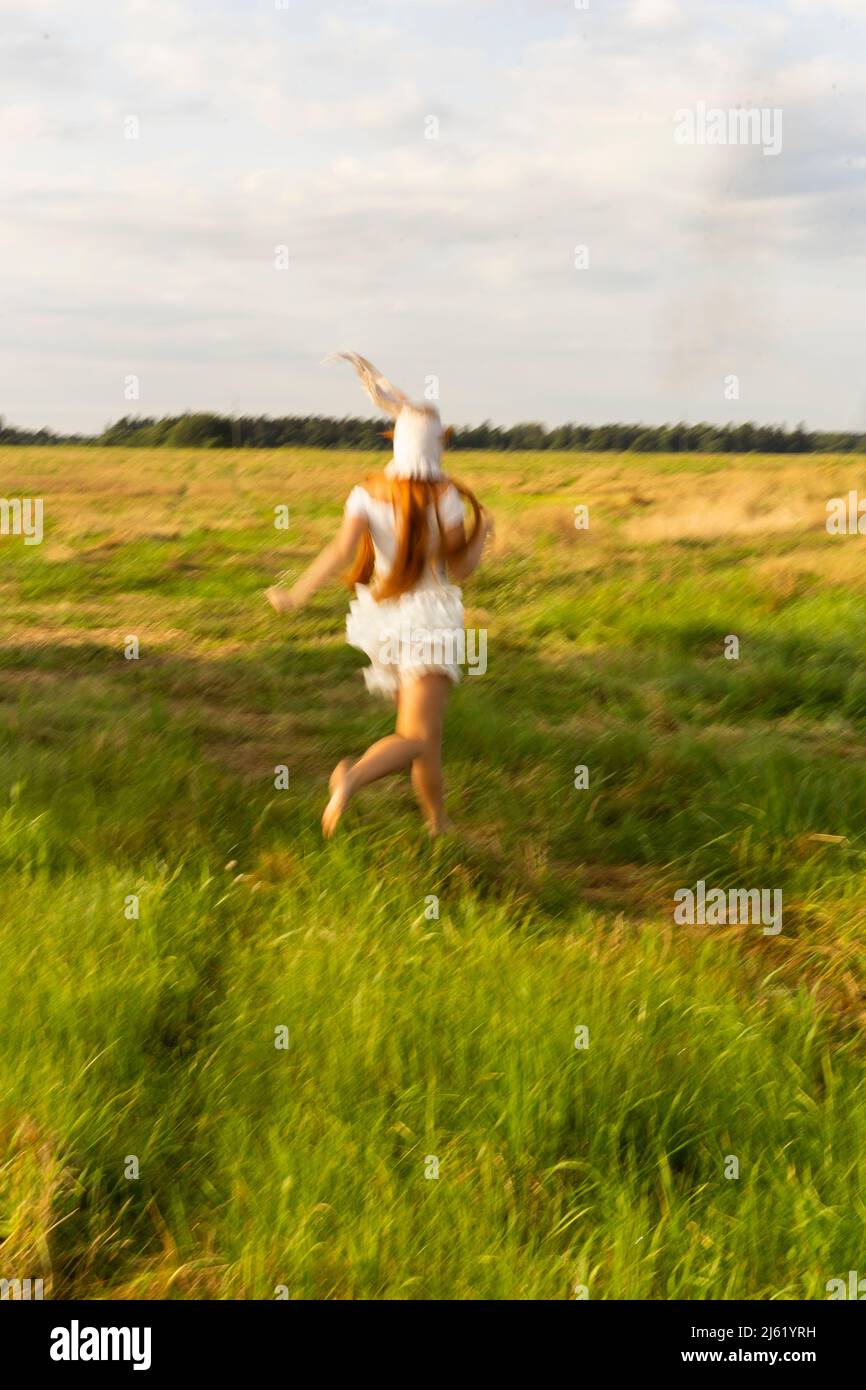 Junge Frau, die auf dem Grasfeld läuft Stockfoto