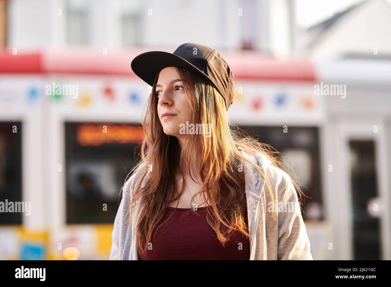 Junge Frau mit Baseballmütze, die in der Stadt steht Stockfoto