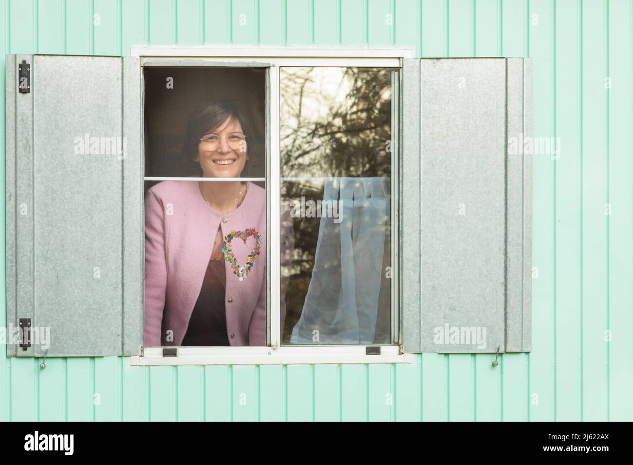 Lächelnde Frau, die vom Anhänger aus durch das Fenster schaute Stockfoto