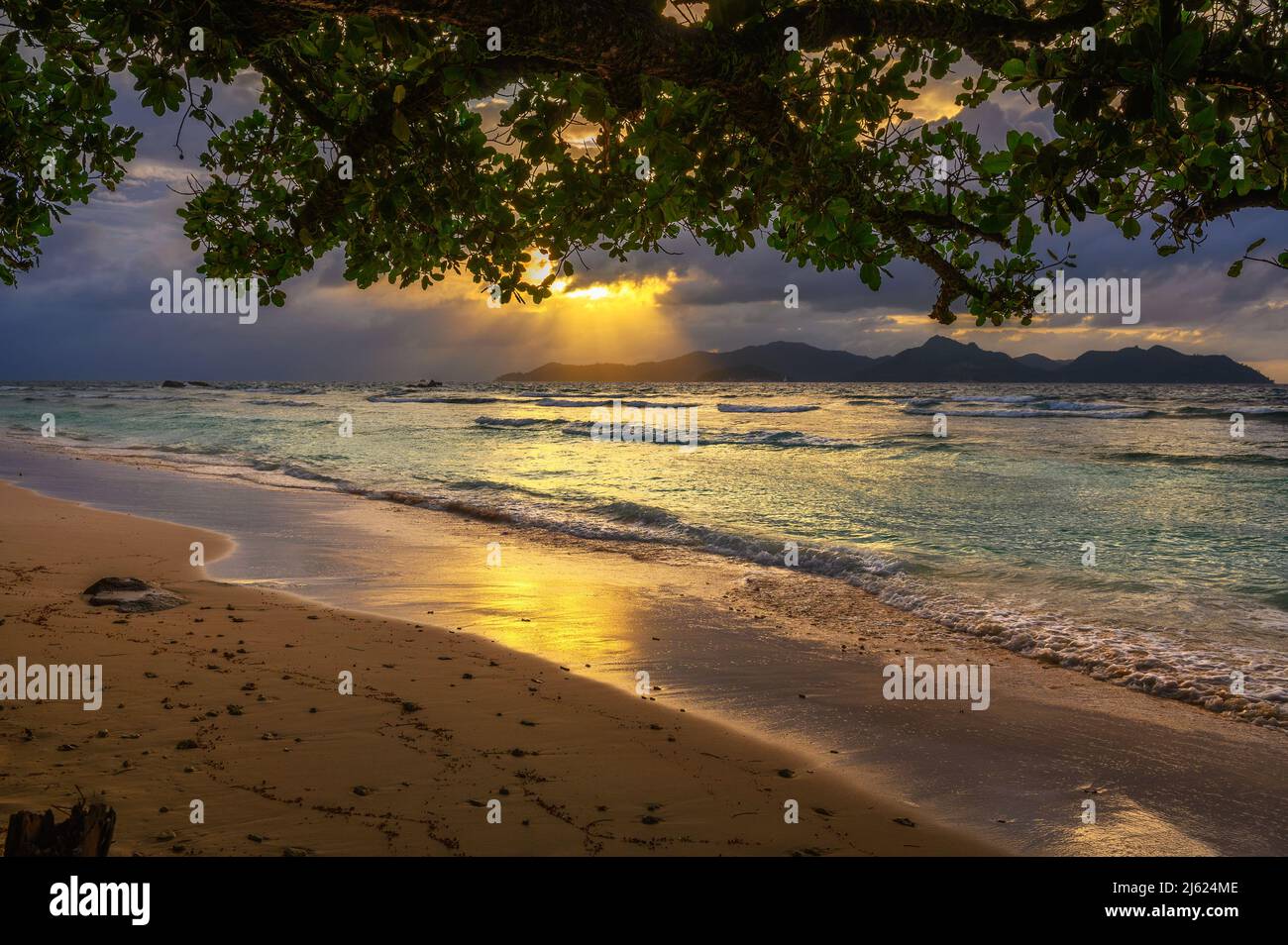 Sonnenuntergang über Praslin Island vom Anse Severe Beach auf der Insel La Digue, Seychellen Stockfoto