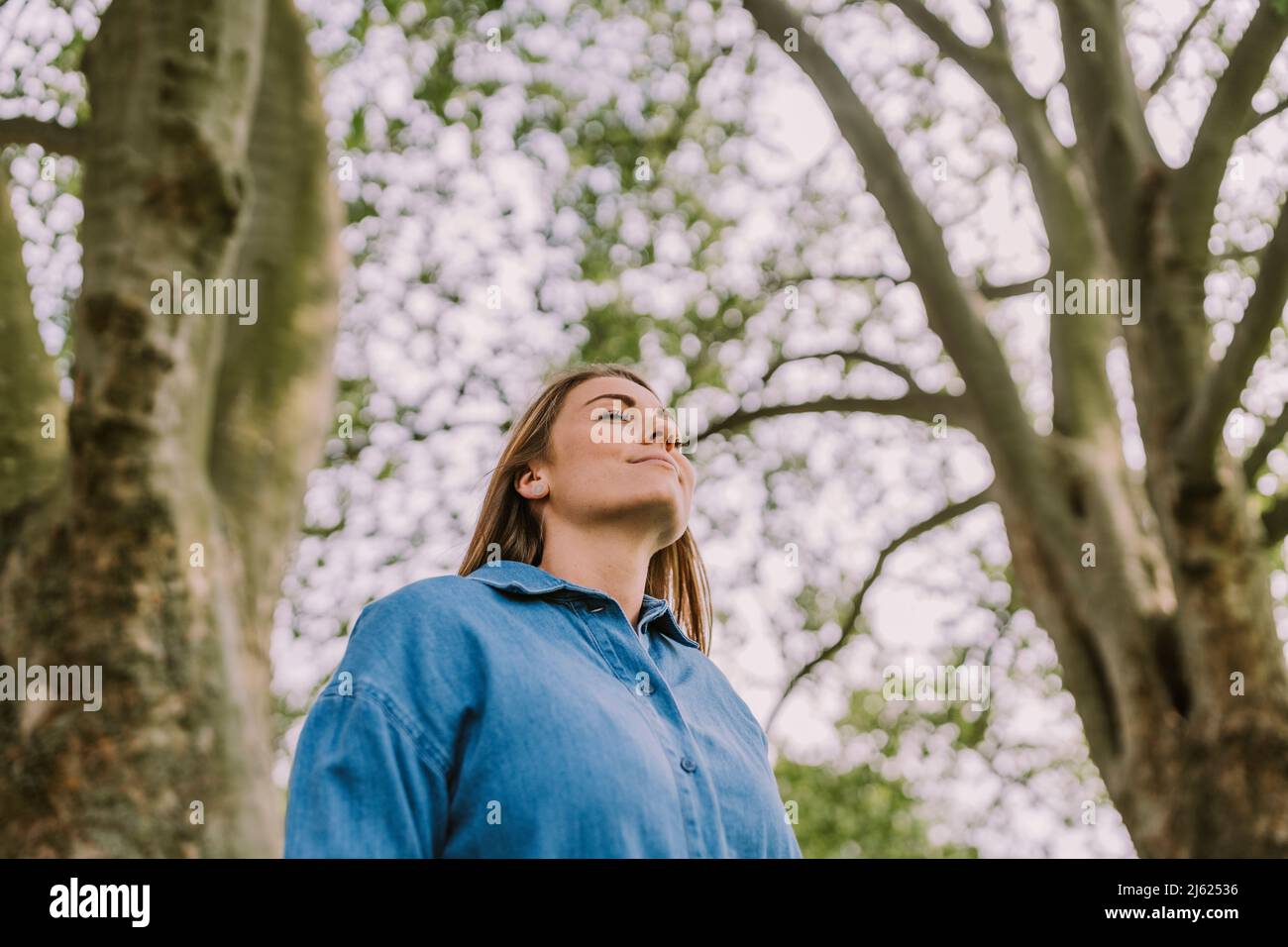 Junge Frau atmet frische Luft in der Natur ein Stockfoto