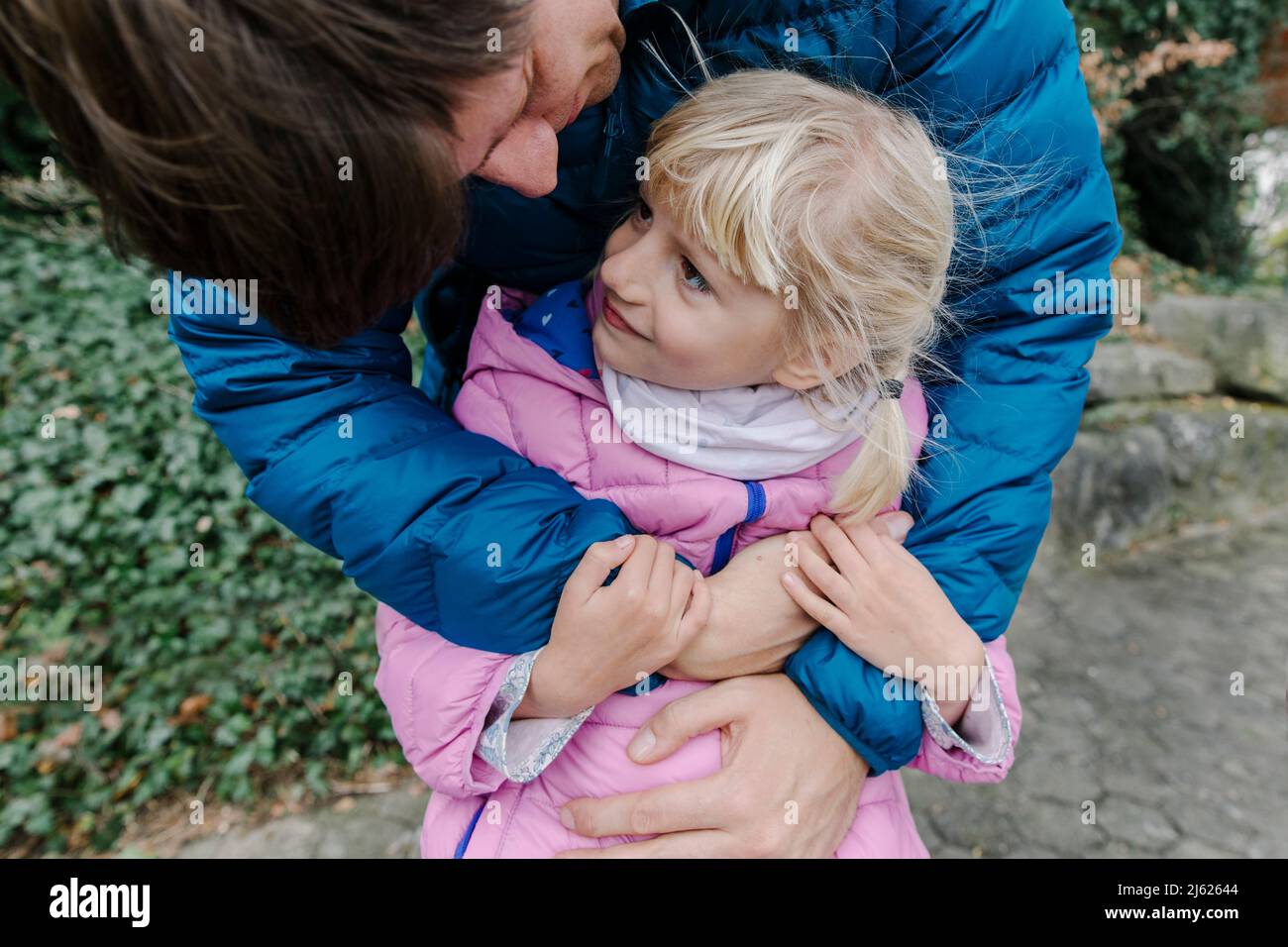 Glücklicher Vater umarmt Tochter im Freien Stockfoto