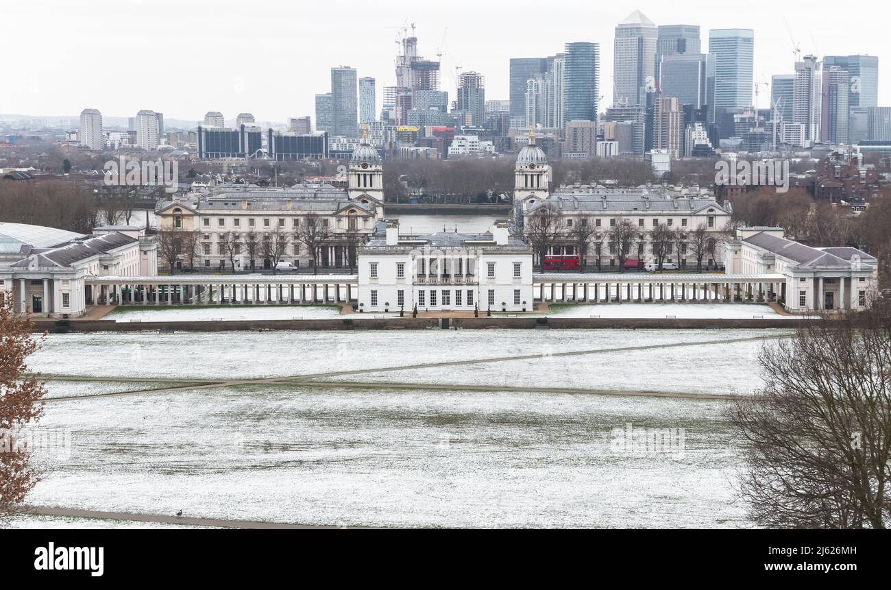 Blick auf das Queens House und Canary Wharf vom Greenwich Park in London im Winterschnee Stockfoto