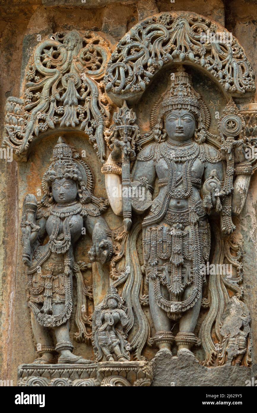 Ein hinduistischer Gott und eine Göttin unter den Schnitzereien am Hoysaleswara Tempel in Halebeedu, Karnataka, Indien Stockfoto