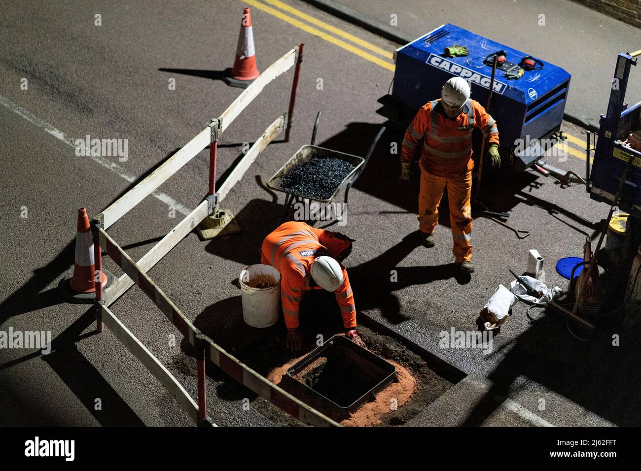 Nächtliche Straßenarbeiten, bei der eine kaputte Schachtabdeckung auf der Straße repariert wurde, in Hertfordshire, Großbritannien. Von den Auftragnehmern Cappagh im Auftrag von Thames Water durchgeführte Arbeiten. Foto: David Levenson/Alamy Stockfoto