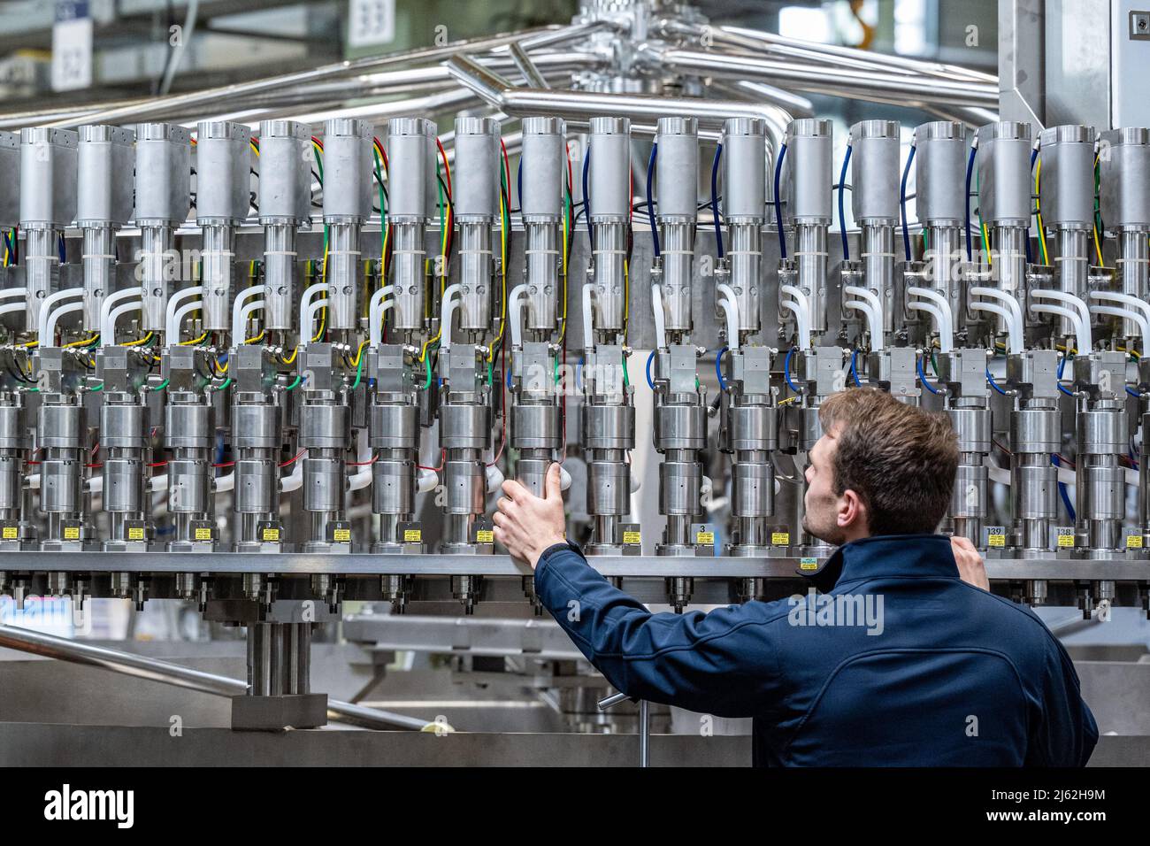 Neutraubling, Deutschland. 25. April 2022. Ein Mitarbeiter der Krones AG arbeitet an einer Abfüllanlage in der Produktion. Quelle: Armin Weigel/dpa/Alamy Live News Stockfoto