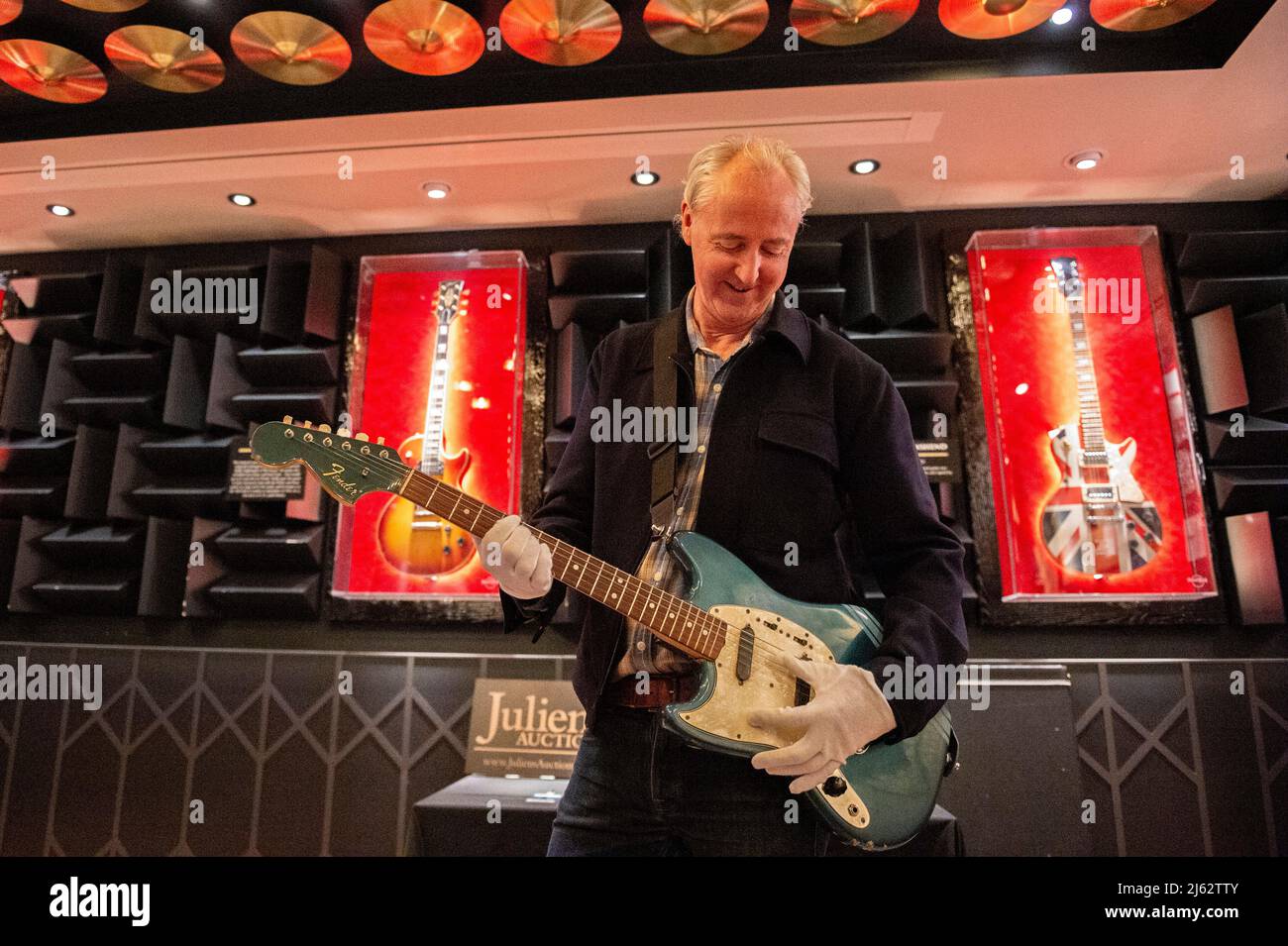 VEREINIGTES KÖNIGREICH. 27. April 2022. Martin Nolan, Executive Director von Julian's Auction, stellt Kurt Cobains ikonisches Musikvideo „Smells Like Teen Spirit“ von 1969 Fender Mustang mit einer Anfangsschätzung von $600.000 bis $800.000 und anderen Musik-Memorabilien am 27. April 2022 im Hard Rock Cafe in Piccadilly in London vor. Die Auktion findet im Rahmen einer dreitägigen Veranstaltung statt, die zwischen dem 20. Und 22. Mai 2022 im New Yorker Time Square Hard Rock Cafe stattfindet. (Foto: Claire Doherty/Sipa USA) Quelle: SIPA USA/Alamy Live News Stockfoto