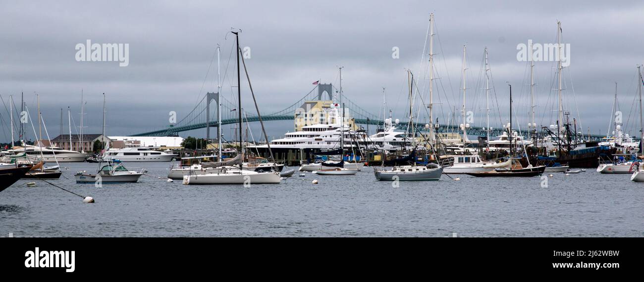 Newport, Rhode Island, USA - 2. Juli 2021: Newport-Hafen mit vielen festfahrenden Segelbooten und Yachten mit der newport-Brücke im Hintergrund auf einer wolkenbewb Stockfoto