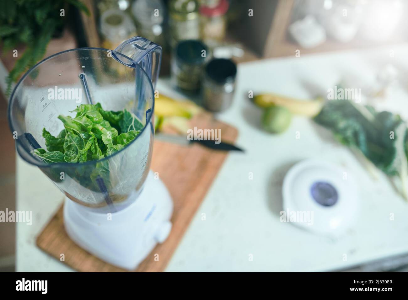 Grüner Smoothie mit Mixer in der heimischen Küche Stockfoto