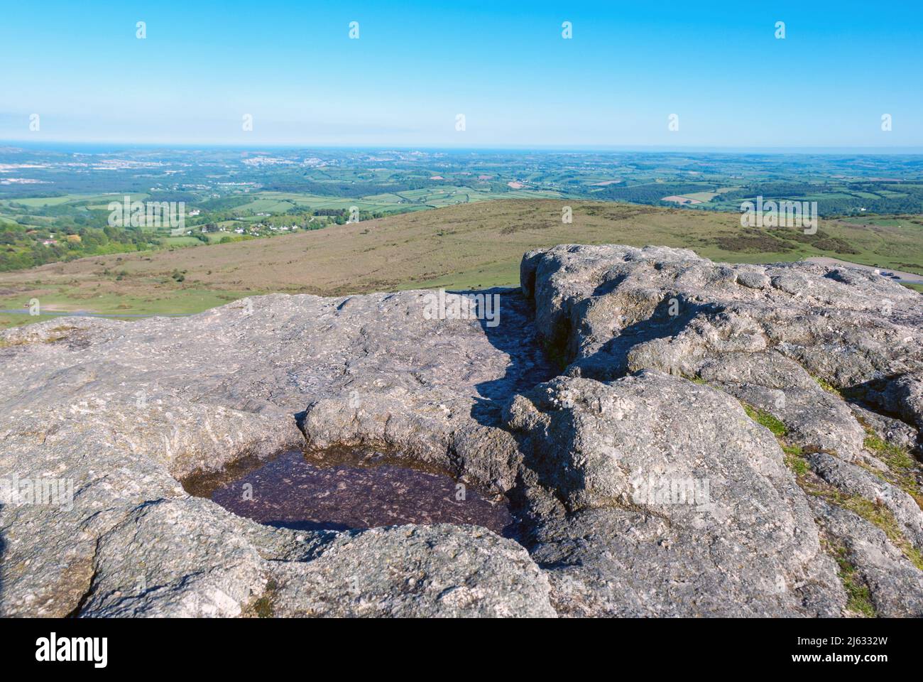 Großbritannien, England, Devonshire, Dartmoor. Ein Felsbecken auf Heytor Rocks. Blick auf das Meer. Stockfoto