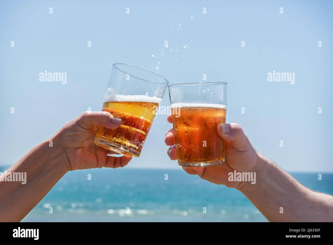 Toast an einer Strandbar mit Bier. Freude für den Sommer, Sonne und Urlaub Stockfoto