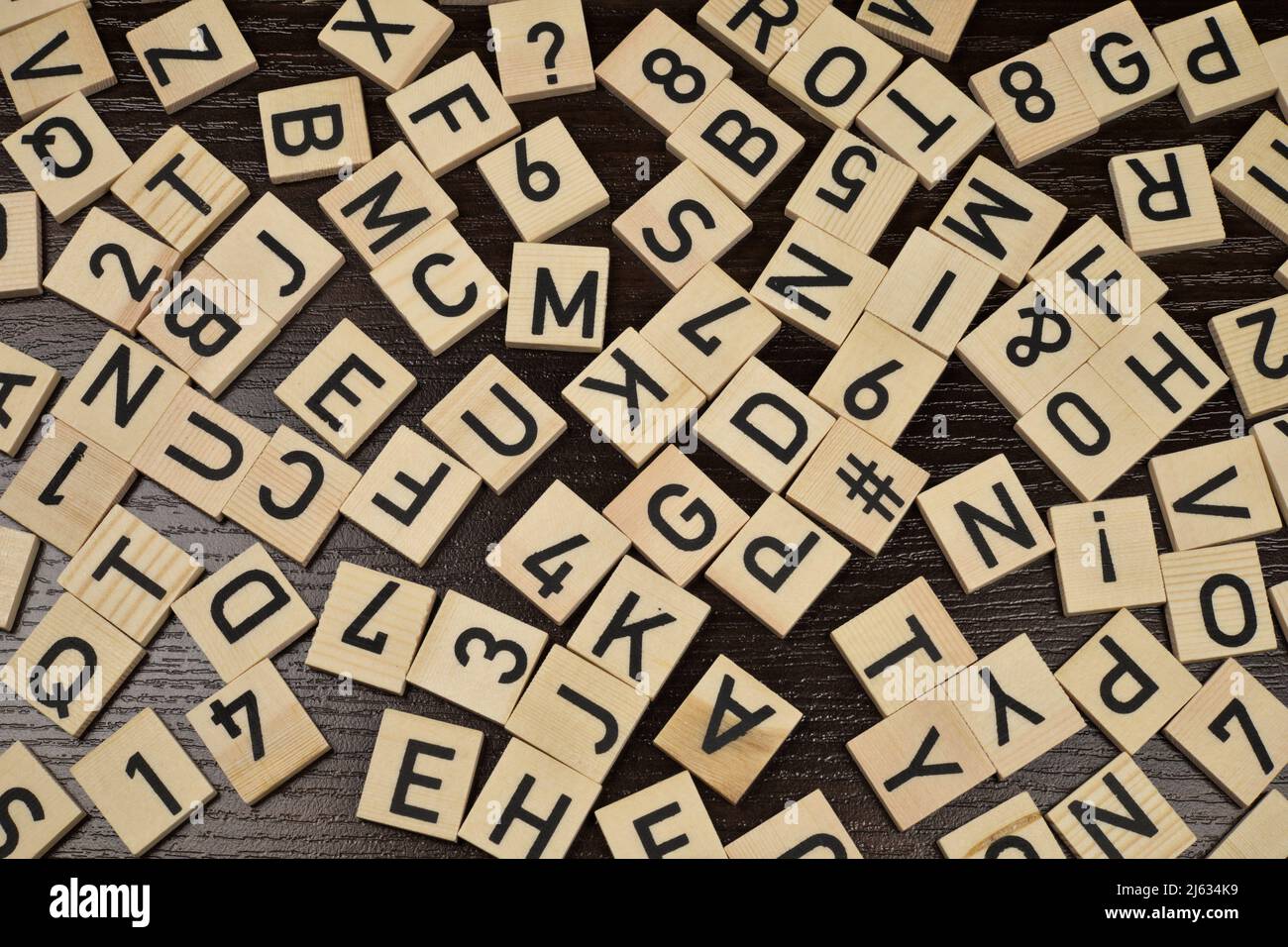 Holzfliesen mit lateinischen Buchstaben und Schriftzeichen, brauner Hintergrund Stockfoto