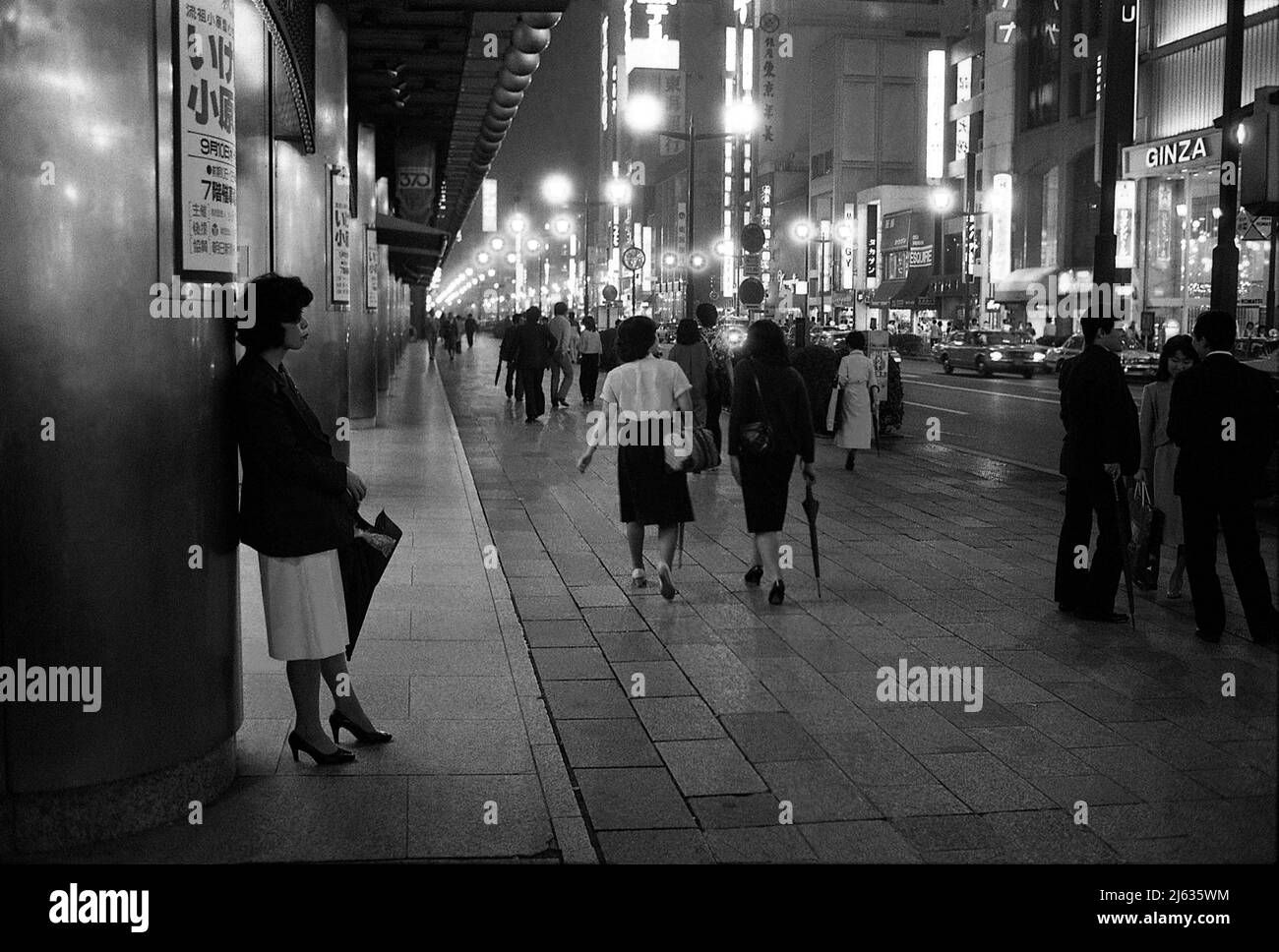TOKYO JAPAN Woman wartend, gelehnt´s einer Fassade im Geschäftsviertel von Tokio negativ 30716 Stockfoto