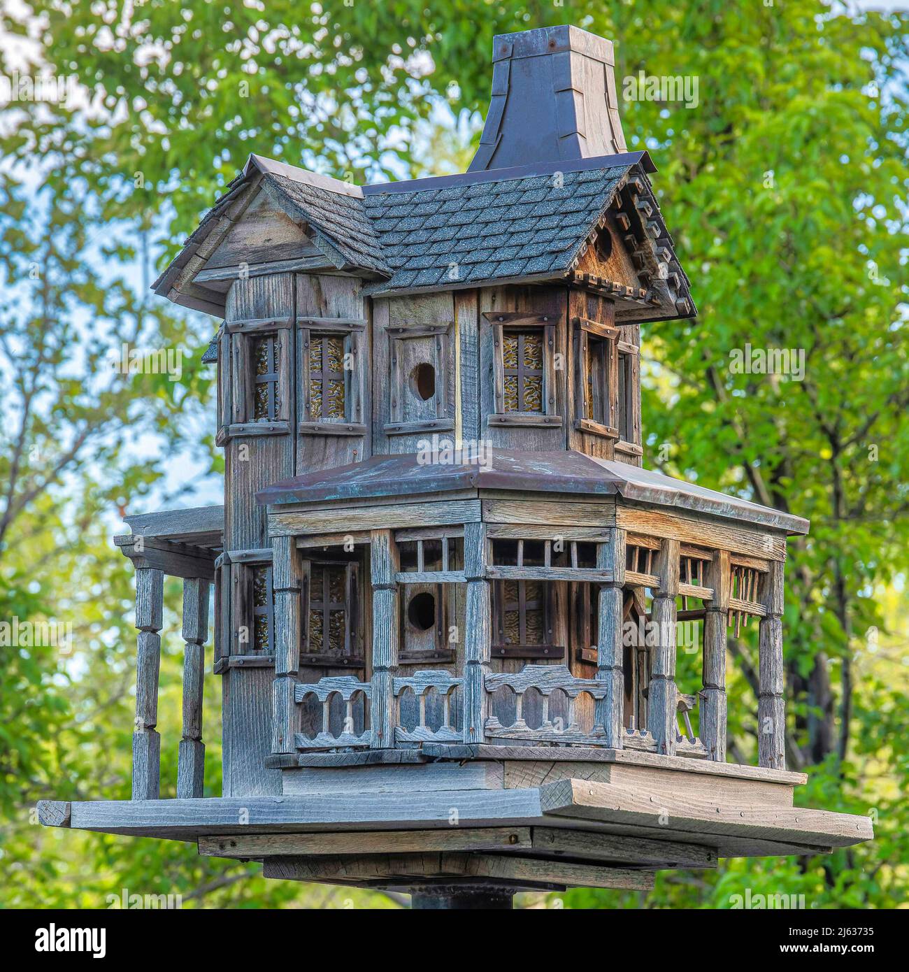 Quadratisches Vogelhaus aus Holz auf einem Metallpfosten in Daybreak, Utah Stockfoto