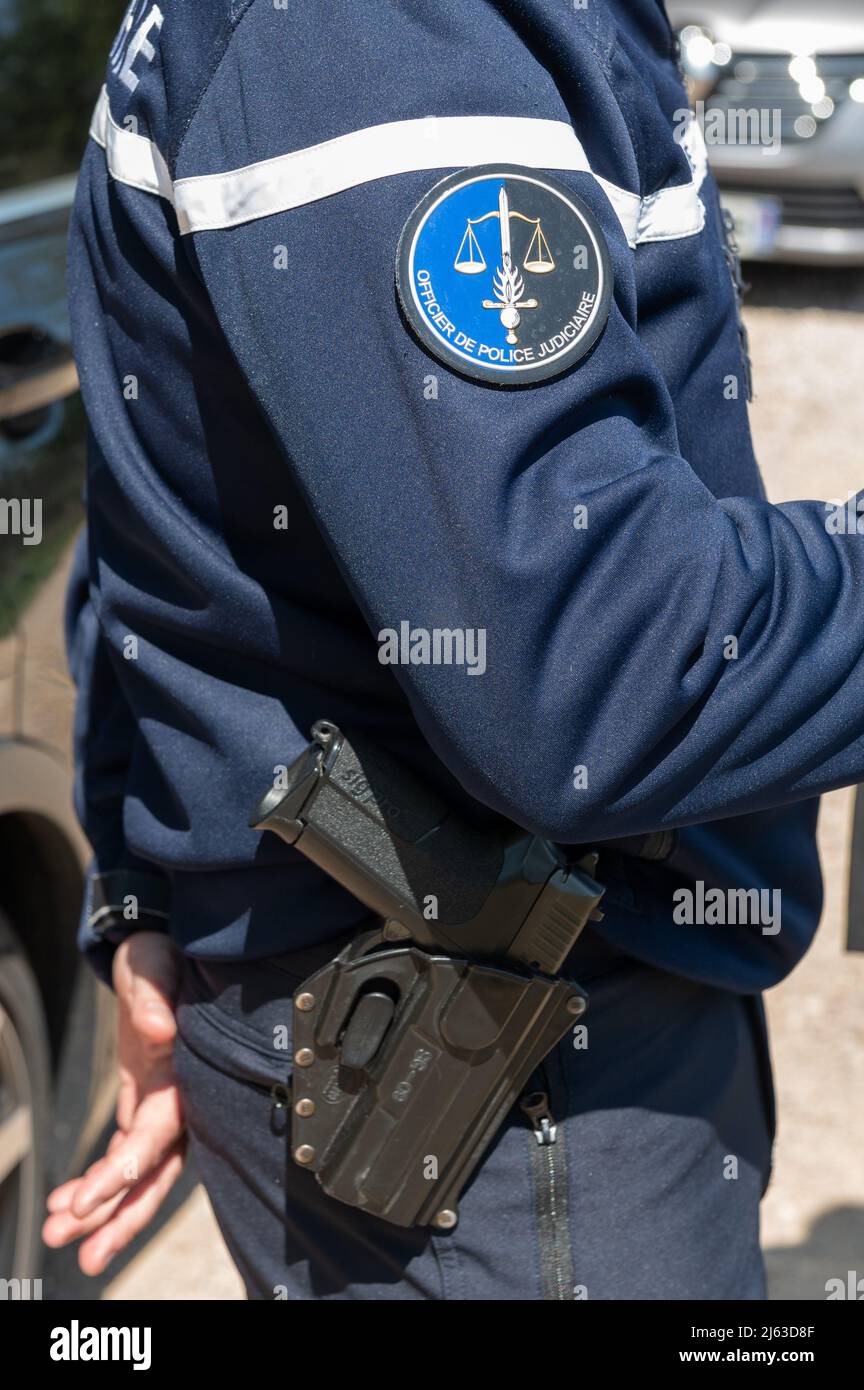 Eine Pistole wird von einem Justizpolizisten getragen, das Logo ist auf dem Ärmel seiner Uniform angenäht. In Erwartung des zunehmenden Verkehrs an der französischen Riviera während der Ferienzeit werden regelmäßig Kontrolloperationen auf den Straßen des Var durchgeführt. Die Statistiken zur Verkehrssicherheit sind seit Anfang des Jahres 2022 im Departement Var schlecht und die Zahl der Verkehrstoten ist gestiegen. Stockfoto