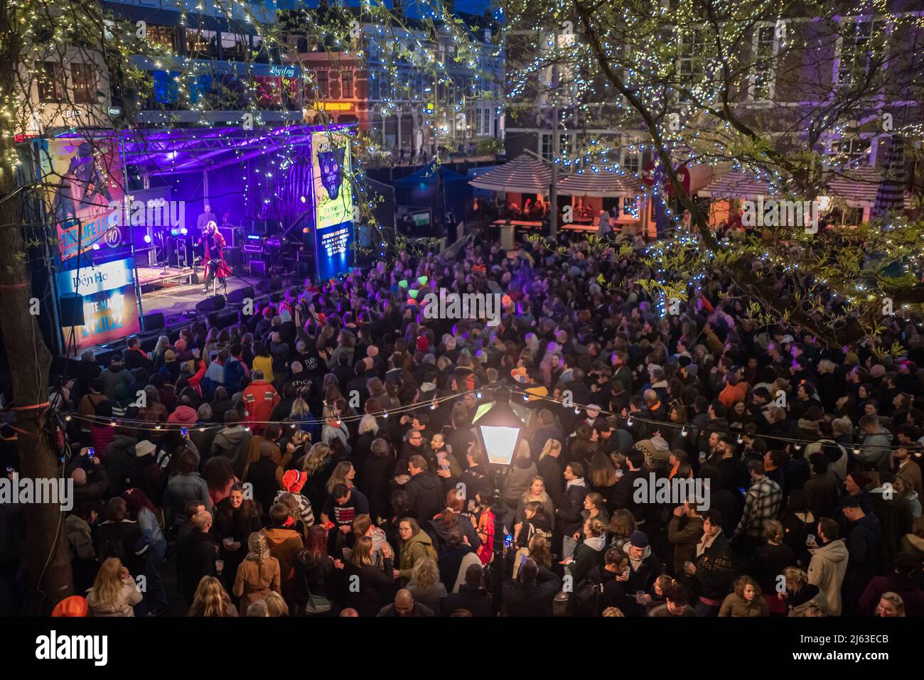 Party-Favelas in vollem Gange auf dem Grote Market in Den Haag, während des Festivals vom Zwarte Ruiter aus gesehen. DAS LEBEN, DAS ICH LEBE. Das zweitägige Festival beginnt am Abend vor dem Königstag an der Königsnacht (Koninsnacht). Das Musikfestival im Freien, das den Geburtstag des Königs feiert, findet jedes Jahr am 26. Und 27. April im Stadtzentrum von Den Haag statt. Die Feier ist eine landesweite Veranstaltung. Zahlreiche Interpreten sind gleichzeitig in ganz Den Haag auf der Bühne, und der diesjährige Eröffnungsakt von 2022 ist die ukrainische Elektro-Folk-Band ‘GO A.' Die Gruppe wurde Fünfter beim letztjährigen Eurovision Song Contest Stockfoto