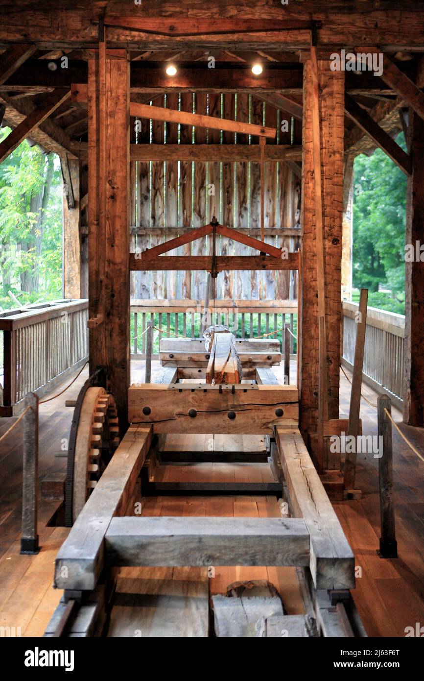 Das Innere eines alten Sägewerks, das den Transportmechanismus aus Holz und antike Werkzeuge zeigt. Stockfoto