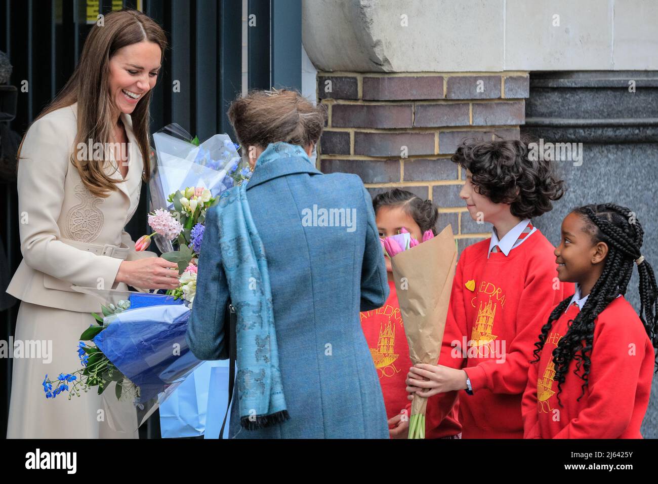 London, Großbritannien. 27. April 2022. Die königlichen Besucher werden von örtlichen Schulkindern mit Blumen überreicht. Die Prinzessin Royal, Patron, das Royal College of Hebammen (RCM), und die Herzogin von Cambridge, Patron, das Royal College of Obstetricians and Gynecologists (RCOG), werden das RCM und das RCOG-Hauptquartier in London besuchen. Das Zentrum, in dem sich eine Reihe von Frauenorganisationen befinden, die sich für die Verbesserung und Förderung der Gesundheitsversorgung von Frauen einsetzen, wurde von der RCOG entwickelt, um die Zusammenarbeit im gesamten Sektor zu fördern. Kredit: Imageplotter/Alamy Live Nachrichten Stockfoto