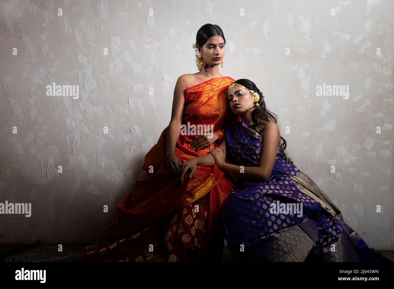 Zwei indische Frauen in traditionellem indianischen Orange und blauem Saree Stockfoto