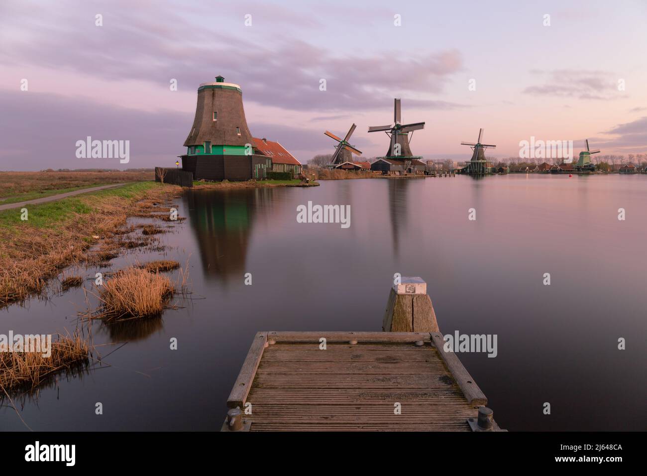Blick auf die niederländischen Windmühlen bei Sonnenuntergang in Zaanse Schans, Niederlande Stockfoto