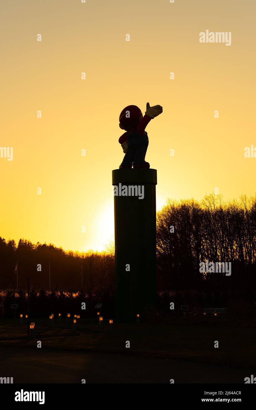 Kungsbacka, Schweden - Januar 30 2022: Supermario-Statue auf einem hohen Mast bei einem goldenen Sonnenuntergang Stockfoto