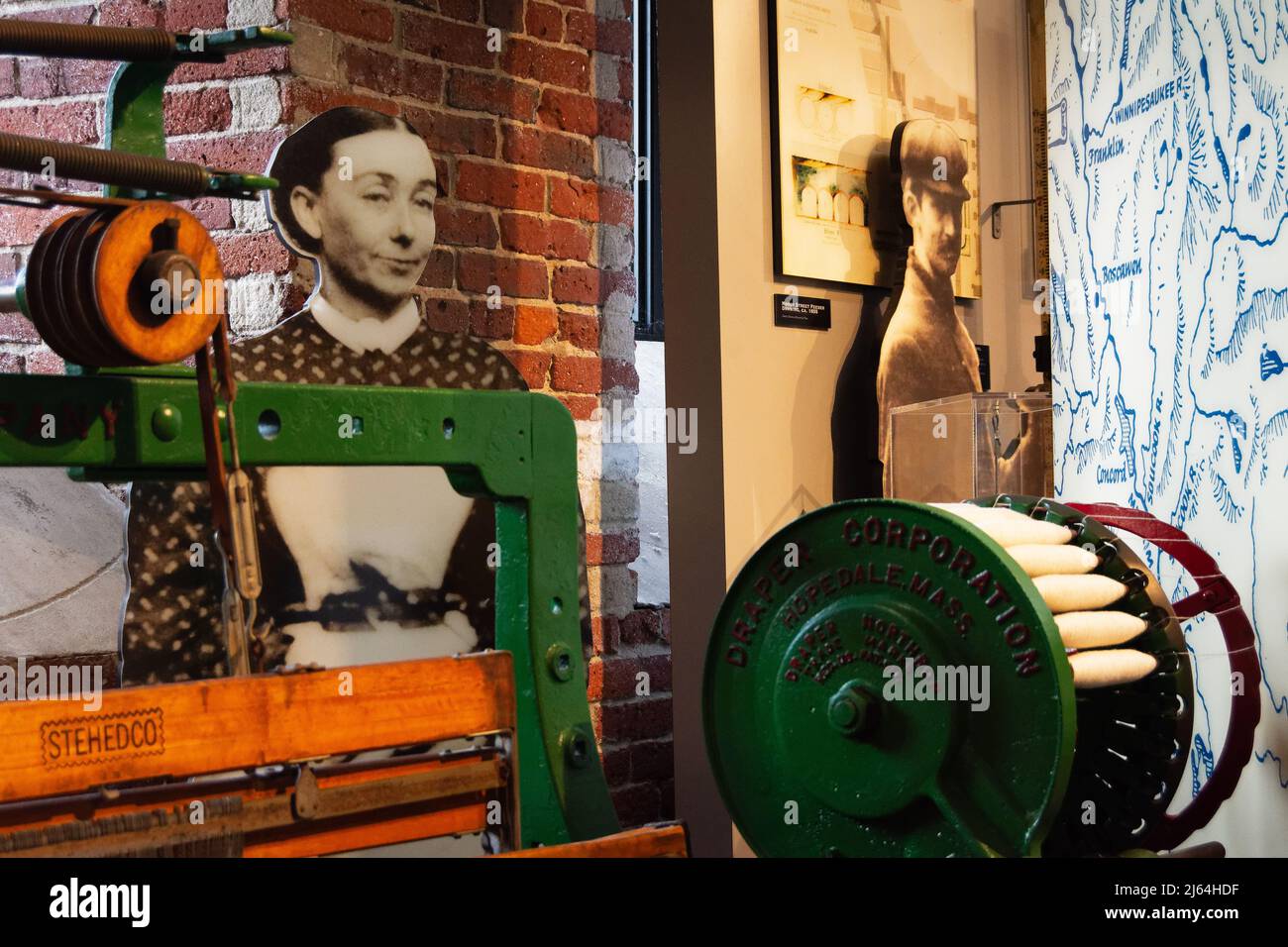 Ein Holzschnitt einer Mühlenfrau, die hinter einem Textilwebstuhl im Besucherzentrum des Lowell National Historic Park in Lowell, Massachusetts, schleift. Horizontal Stockfoto