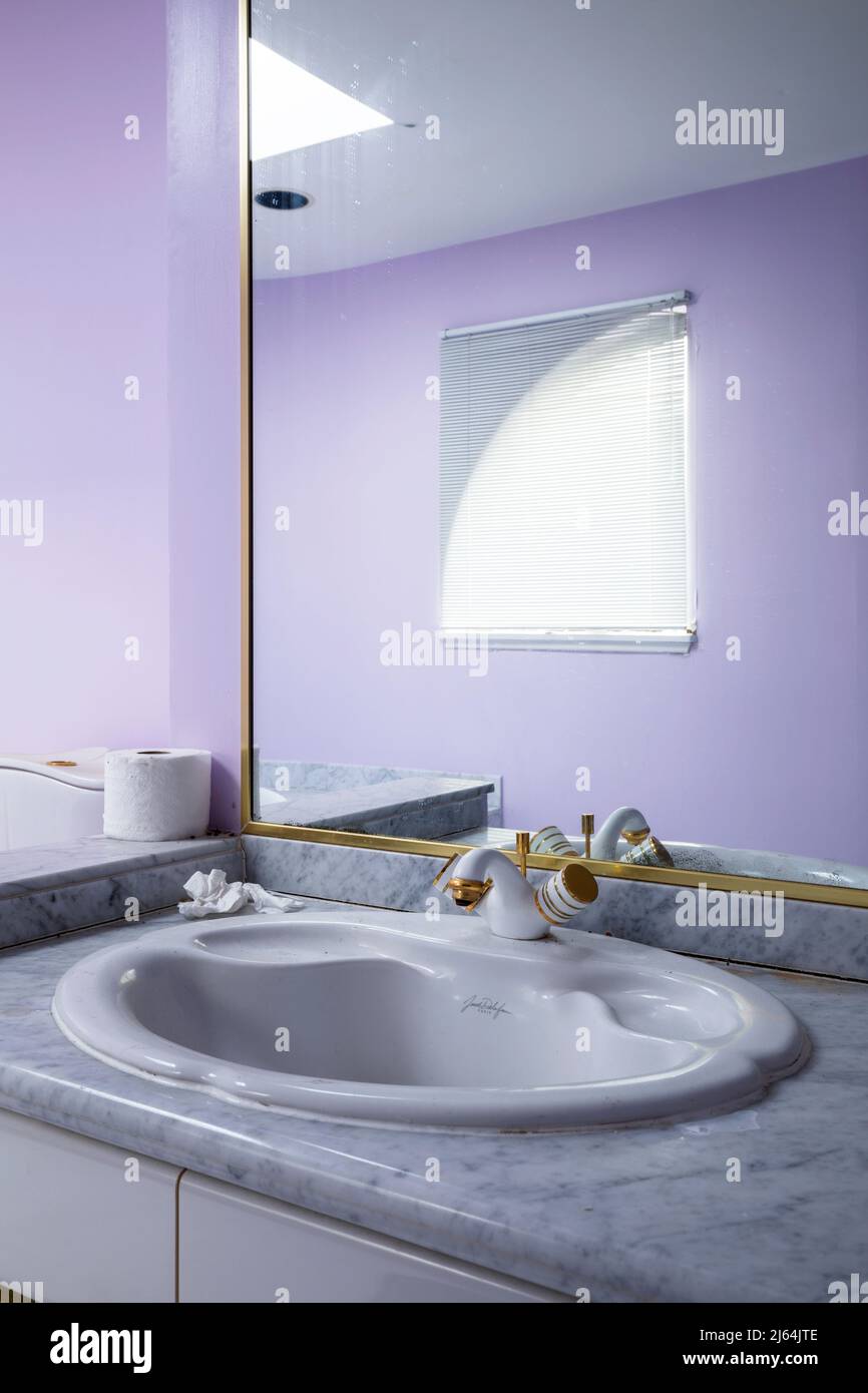 Ein lila Retro-Badezimmer in einem verlassenen Haus. Stockfoto